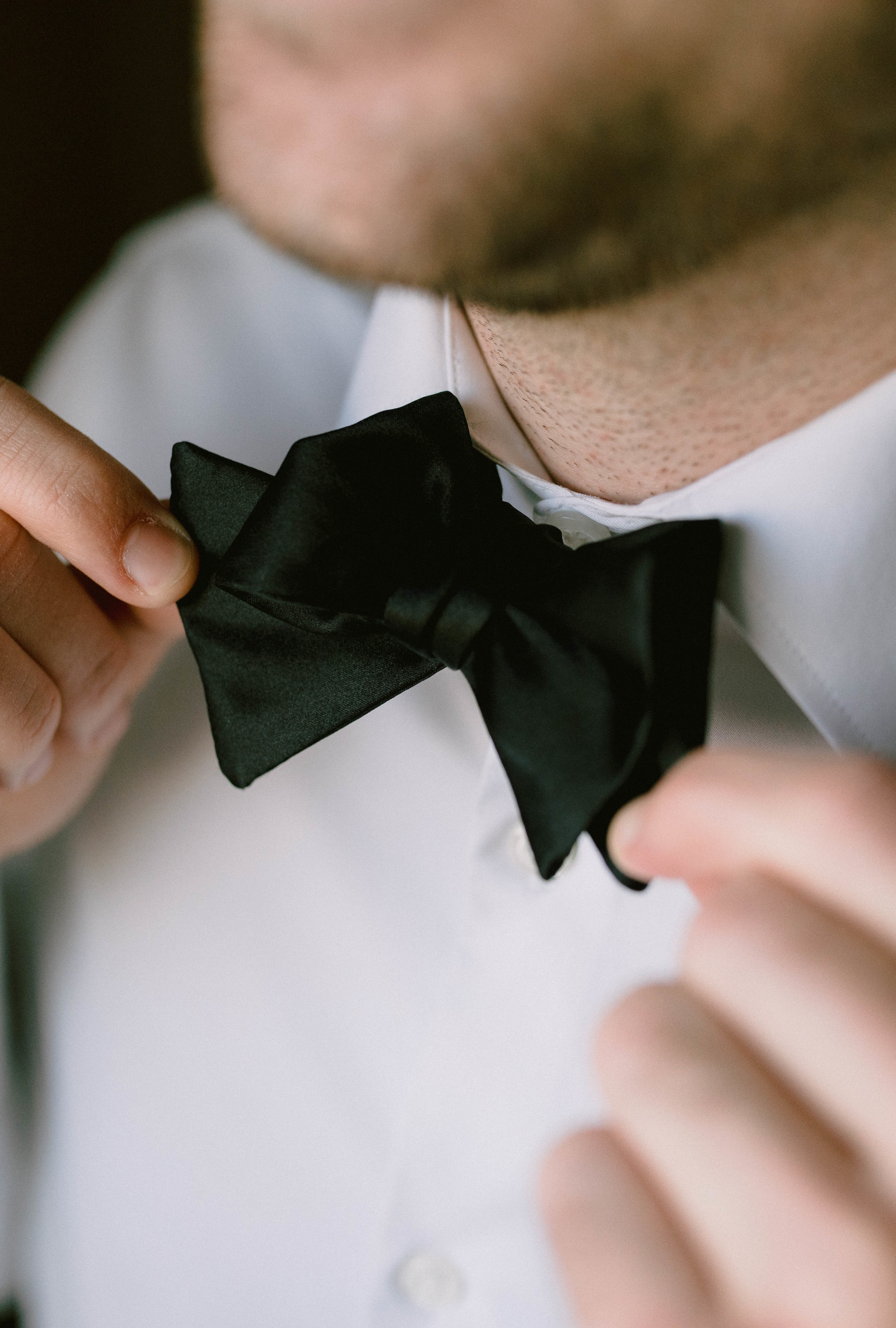 groom wearing a bold bowtie and getting ready for his wedding
