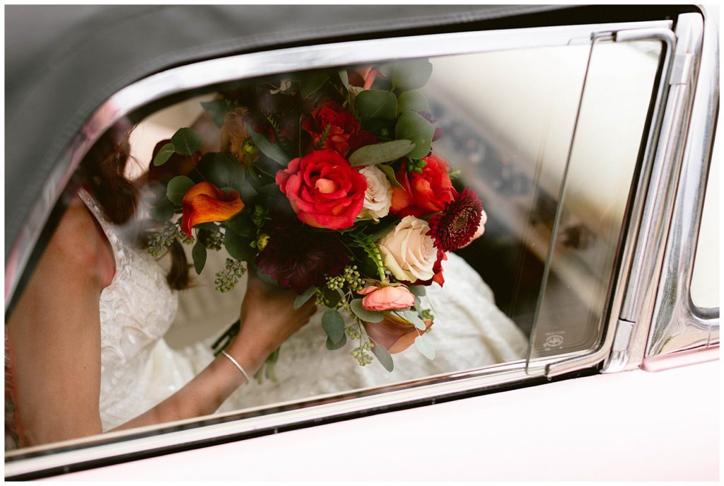 Photo of wedding bouquet as bride and groom are driving off in classic get away car to their reception in detroit michigan.