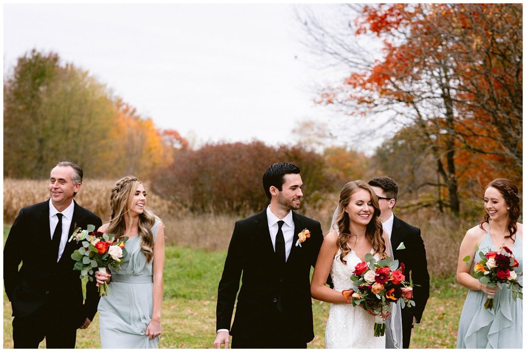 groom laughs at bride emotional happiness wedding party wedding party pose for photos at reception in detroit michigan at private estate with fall leaves and beautiful scenery