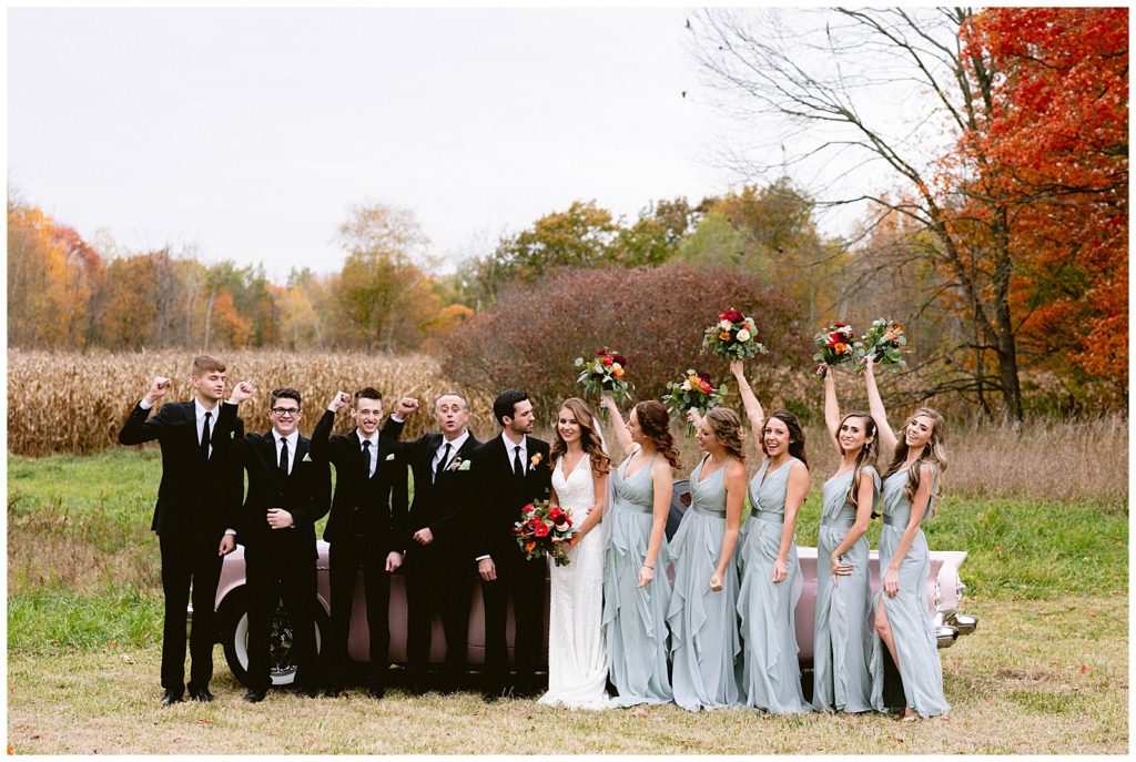 luxury wedding party pose for photos at reception in detroit michigan at private estate with fall leaves and beautiful scenery